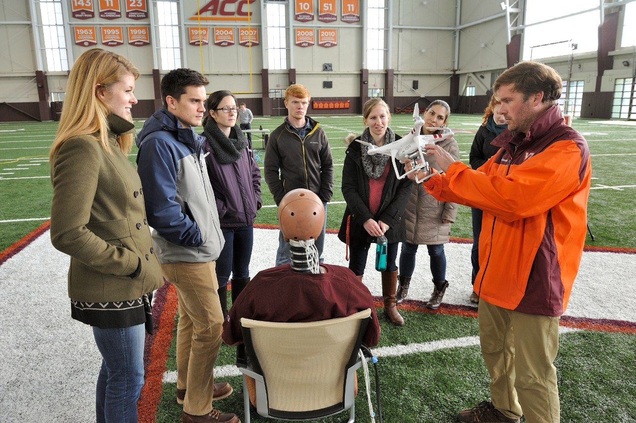 John Coggin, chief engineer at the Mid-Atlantic Aviation Partnership, inspects an aircraft after the impact as members of the injury biomechanics research team look on.