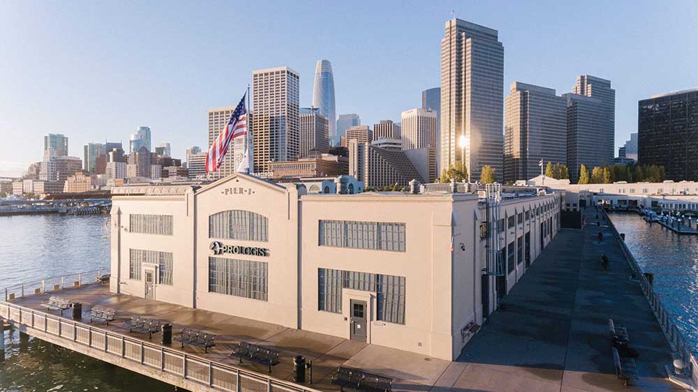 A photo of the Prologis corporate office at Piere 1 in San Francisco. The Prologis logo is displayed on the back of the building, and in the background is the San Francisco skyline.