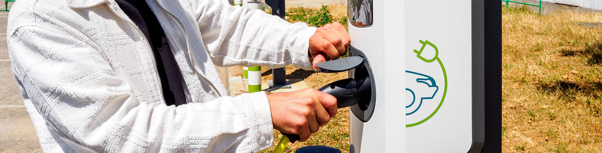 Prologis Workplace Charging: Guy plugging in the charging cable into the charging station
