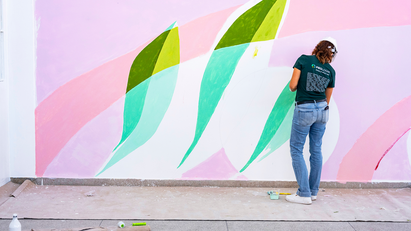 A woman painting a mural on a wall