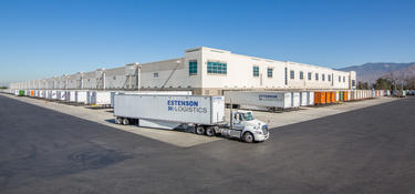An exterior photo of the corner of Prologis Redlands DC7, with trucks in the truck courts with Estenson logistics logos on the side