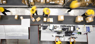 Team members process and sort packages inside a distribution center