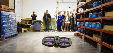 Onlookers view a drone flying inside a Prologis Labs test environment