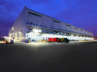 Prologis Timeline - 2009 photo of the exterior of a warehouse and truck court at dusk