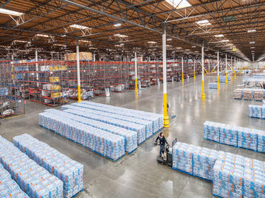 An interior shot of Prologis Kaiser DC5 showing a person on a lift picking up cases of product, and racking in the background.