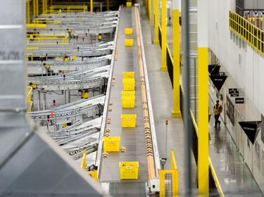a photo of bins moving down a conveyor belt inside the International Park of Commerce warehouse