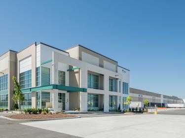 An exterior shot of the front of Prologis Park Tacoma, with the truck court shown in the background and a UPS truck parked outside