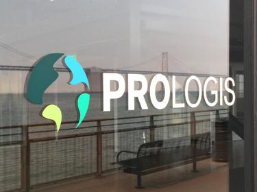 The Prologis logo printed on a window. The reflection is the edge of Pier 1 and a bench facing the bay bridge looking out over the water