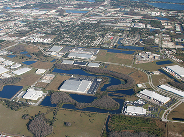 An aerial photo of Libery park. from a bird's eye view there are multiple warehouses surrounded by small bodies of water and greenspace.