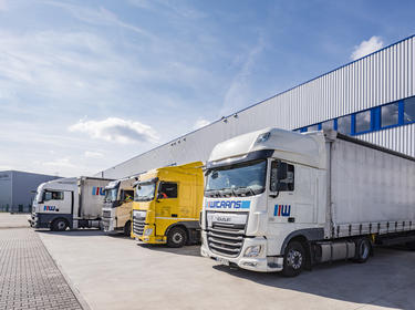 Angled view of warehouse exterior loading dock at Prologis Park Cologne in Cologne, Germany with four semi trucks up close
