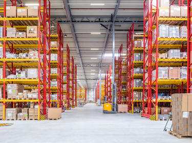 Interior warehouse low angle view of red and yellow racks in Nieuwegin Distribution Center 2 in the Netherlands and blurred forklift