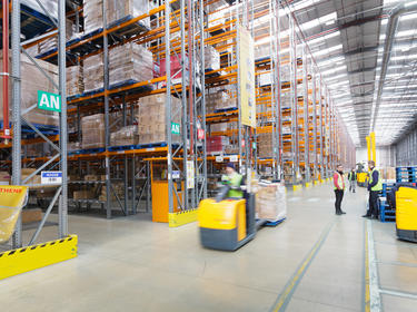 Interior warehouse shot in Prologis RFI DIRFT Sainsbury in the UK showing two workers having a discussion and a forklift in motion