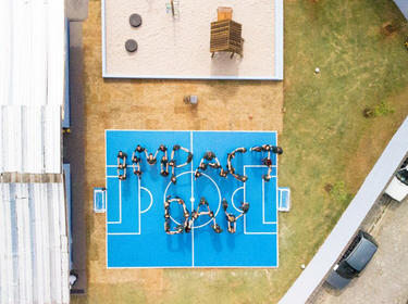Aerial view of a basketball court with a group of Prologis employees forming IMPACT Day for IMPACT Day 2018 