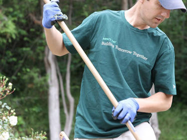A Prologis male employee raking in the garden for IMPACT Day 2018