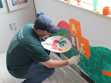 A Prologis employee paints ABC on the wall for IMPACT Day 2019