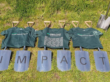 Shovels on the grass spell out IMPACT with three Prologis t-shirts over them for IMPACT Day 2019 