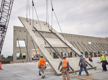 Construction crane lifting an outer wall into place at Gateway Park in Denver, CO