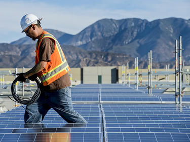 Construction worker installing solar panels in Los Angeles, CA