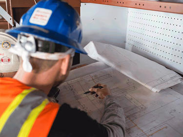 Construction worker reviewing blueprints