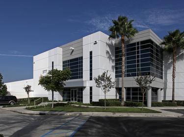 Prologis Timeline - 2015 Photo of the exterior of a warehouse with blue skies and palm trees
