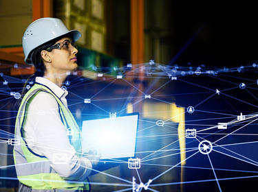 Woman standing in vest and hard hat with graphical representation of connectivity overlayed