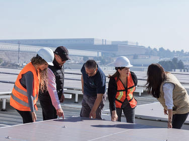 Workers Looking Over Solar Panels