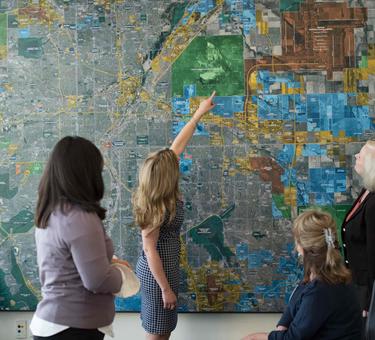 4 women looking at a map of the Denver area on a wall