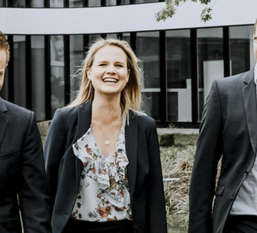 Five team members smiling as they walk outside of the Duesseldorf office
