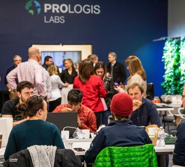 People interact at a table during the US Tour at Prologis Labs