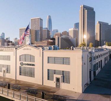 A photo of the Prologis corporate office at Piere 1 in San Francisco. The Prologis logo is displayed on the back of the building, and in the background is the San Francisco skyline.
