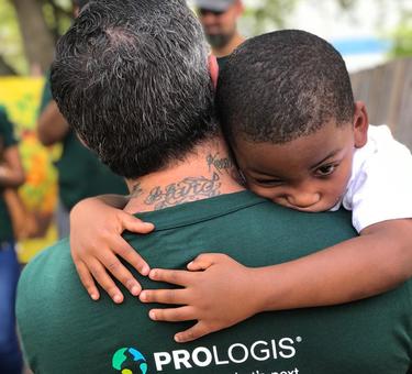 Young child hugging Prologis employee participating in IMPACT Day 2020