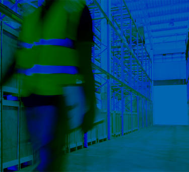 A man walking in a warehouse with a clipboard