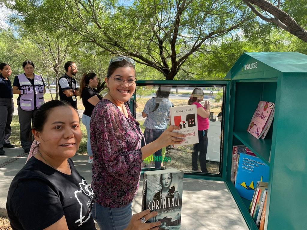 women holding books at outdoor library 