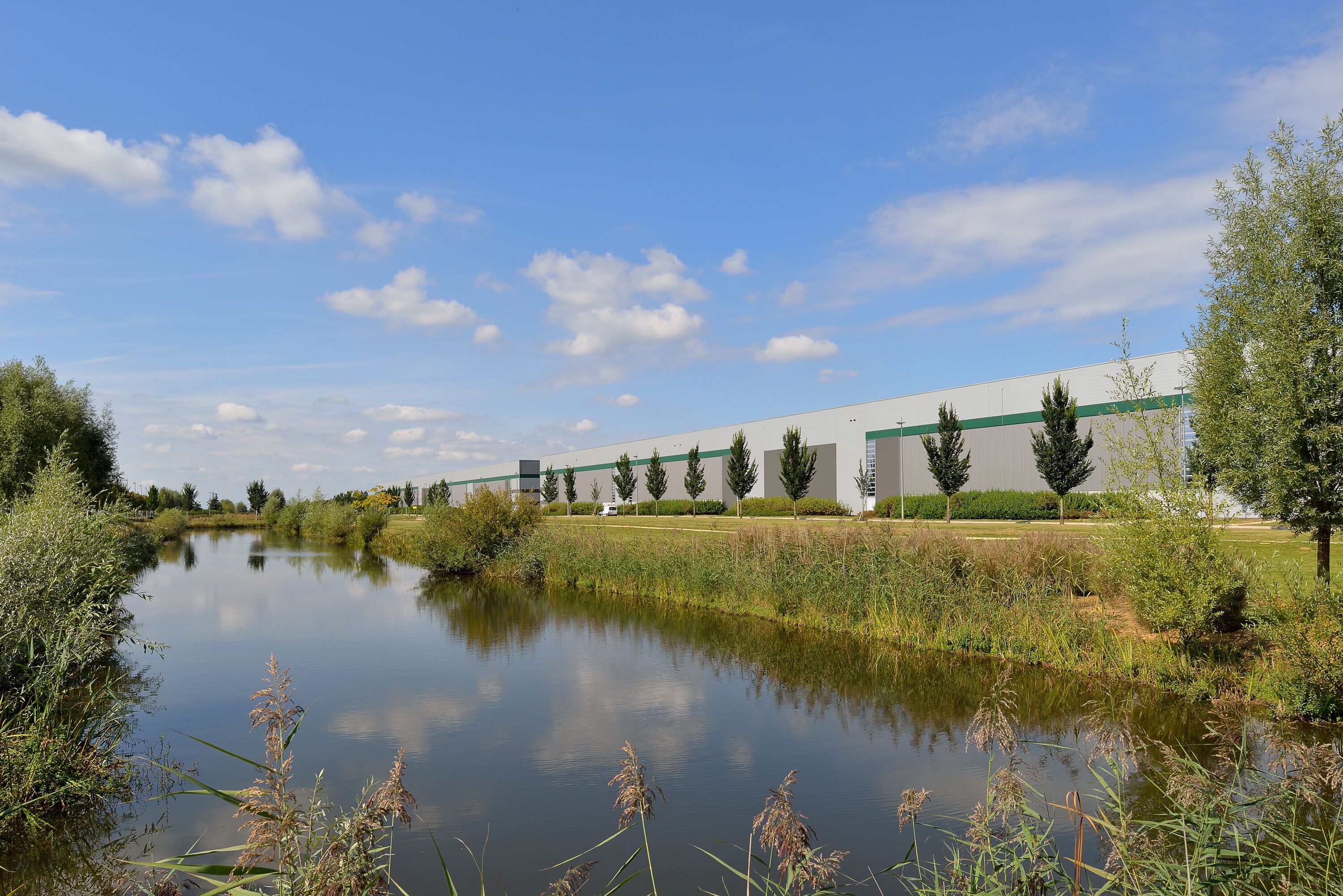 A warehouse with trees and a river in the background A warehouse with trees and a river in the background