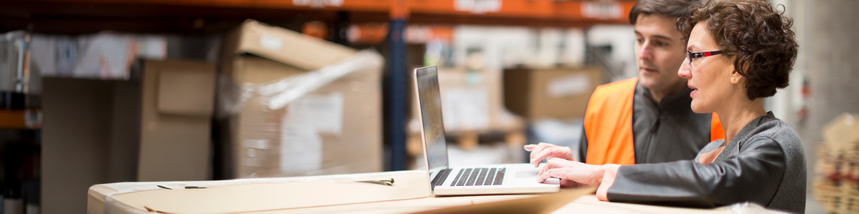 woman on laptop in warehouse woman on laptop in warehouse