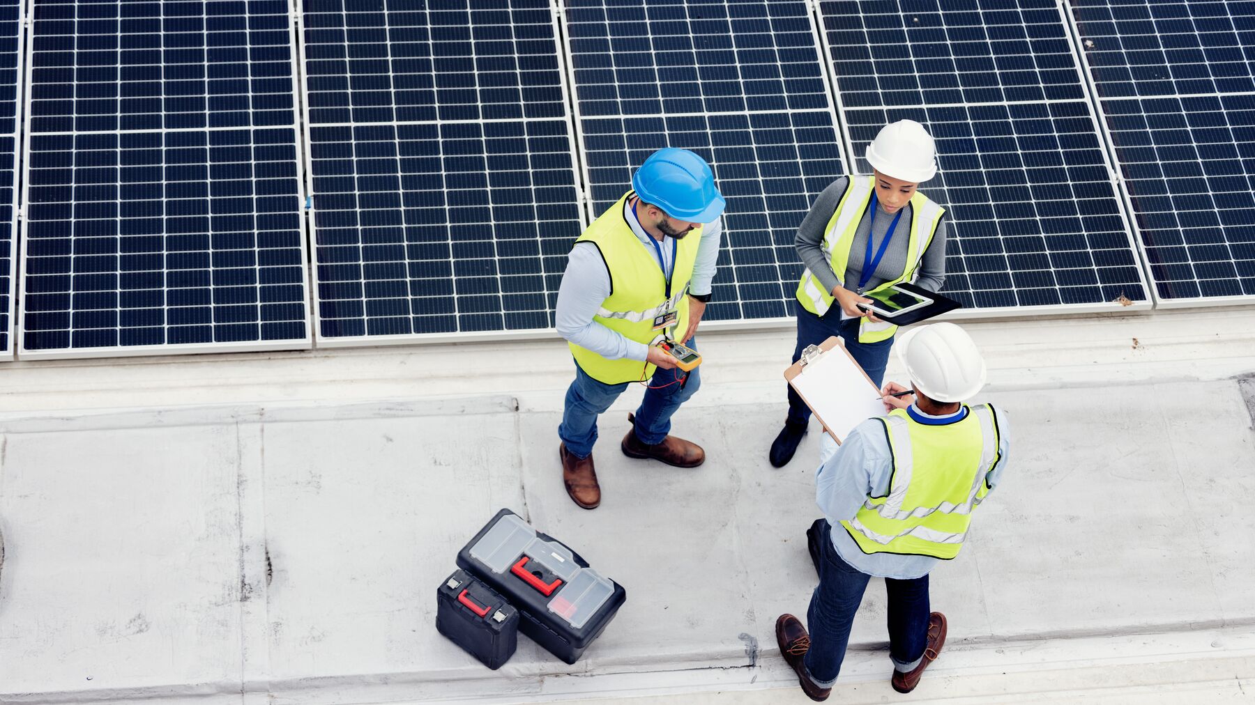 Top view of team of solar workers in discussion for inspection or installation