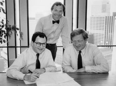 Prologis Timeline - 1983 Douglas Abbey, Hamid Moghadam and T. Robert Burke sitting in an office and smiling