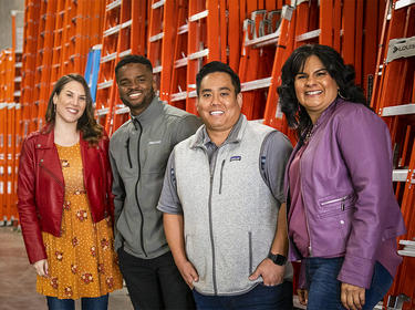 Four members of a Customer Experience Team smile at the camera