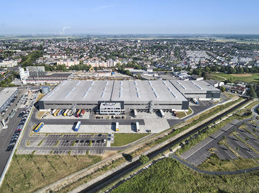 Aerial view of Prologis Pulheim Distribution Center in Germany with green space and railroad tracks surrounding the building exterior