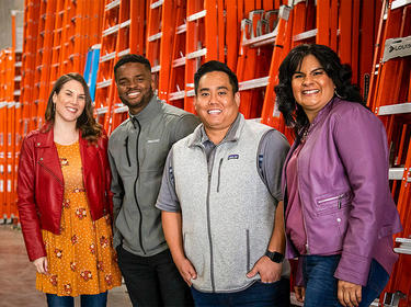 Four members of a Customer Experience Team smile at the camera