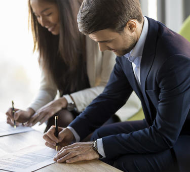  Two people signing business documents